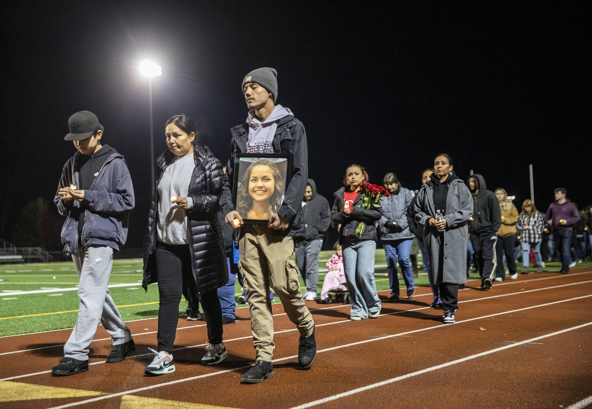 Kordelle Hammond holds a photograph of his cousin Shaylee Chuckulnaskit while her mother Lavina Phillips walks beside him during a memorial walk on the 10-year anniversary of the shooting at Marysville Pilchuck High School on Thursday, Oct. 24, 2024 in Marysville, Washington. (Olivia Vanni / The Herald)