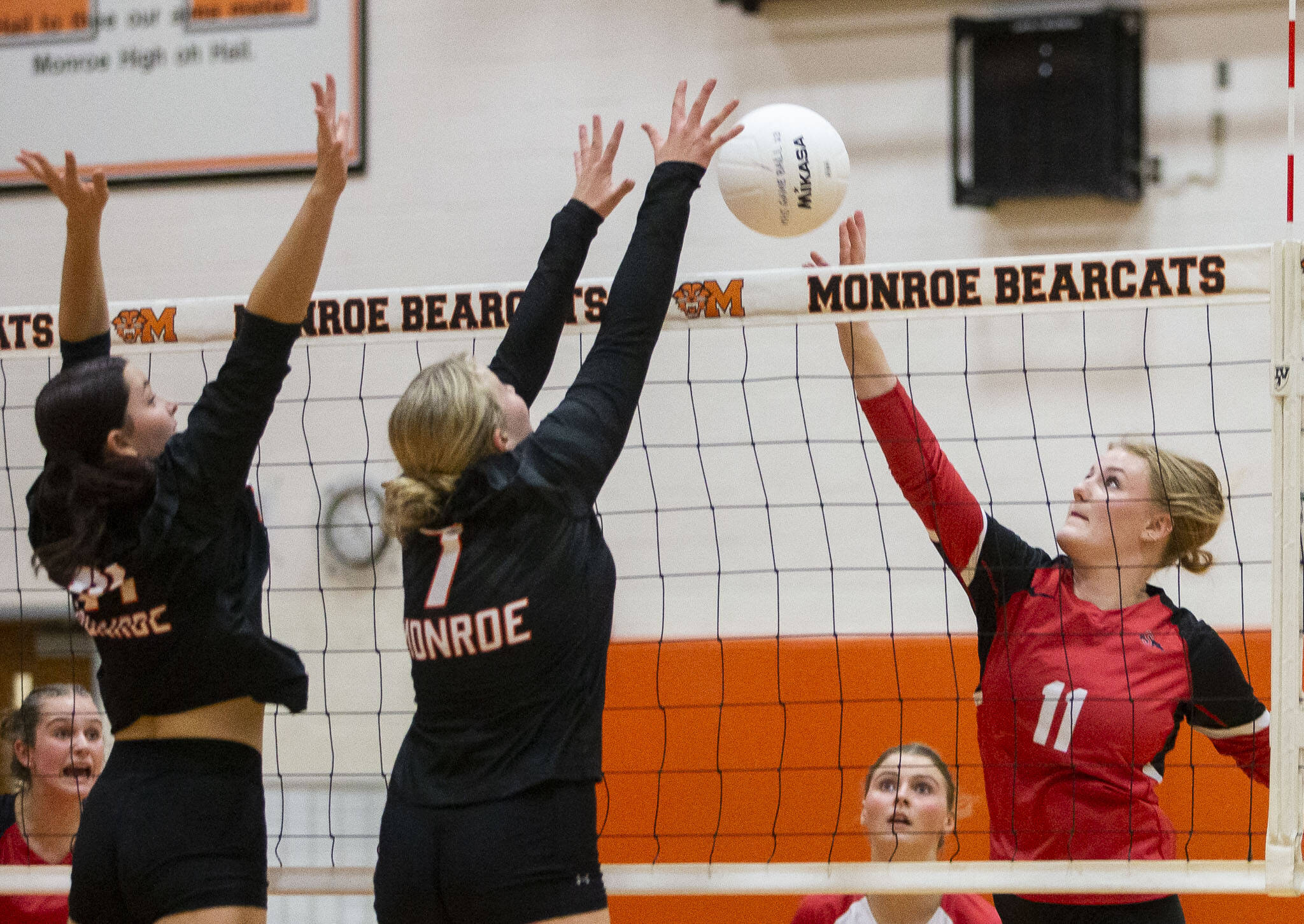 Snohomish’s Keira Beverford tries to tip the ball over the top of outstretched arms of Monroe’s Faith Fodge during the game on Wednesday, Oct. 16, 2024 in Monroe, Washington. (Olivia Vanni / The Herald)