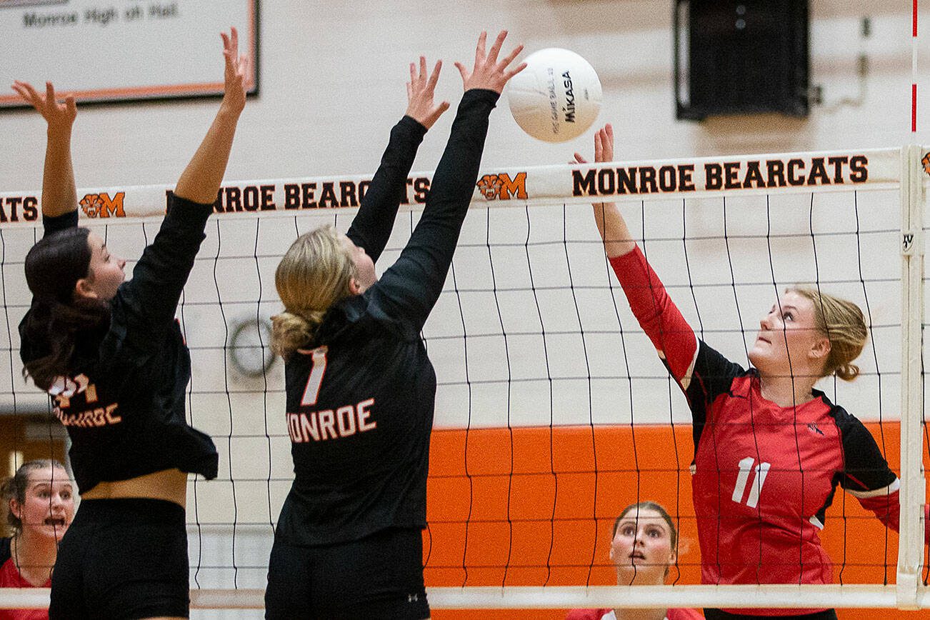 Snohomish’s Keira Beverford tries to tip the ball over the top of outstretched arms of Monroe’s Faith Fodge during the game on Wednesday, Oct. 16, 2024 in Monroe, Washington. (Olivia Vanni / The Herald)