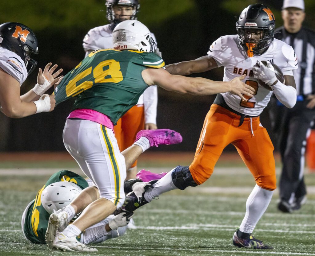 Monroe’s Carl Watson III sticks his arm out to block a tackle during the game against Shorecrest on Friday, Oct. 18, 2024 in Shoreline, Washington. (Olivia Vanni / The Herald)
