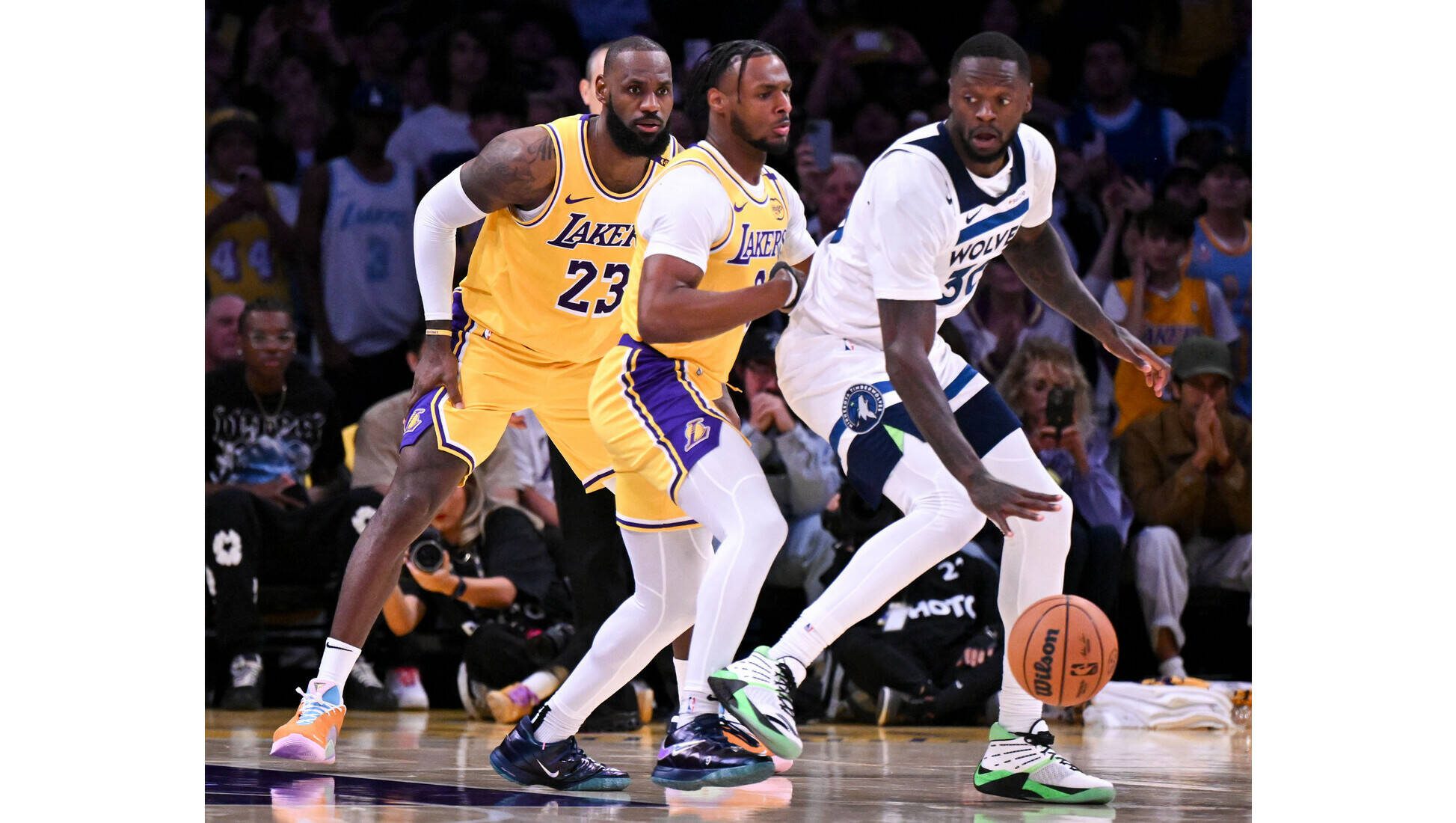 David Crane / Los Angeles Daily News
Lakers star LeBron James, left, watches as his son, Lakers rookie Bronny James, center, defends against the Minnesota Timberwolves’ Julius Randle during the second quarter of the season opener on Tuesday night at Crypto.com Arena. LeBron and Bronny made history as the first father and son to play in an NBA game together.