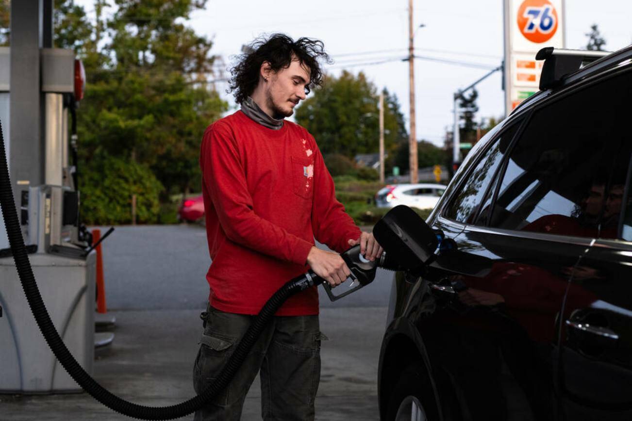 Brandon Borg, 21, fills his gas tank in Everett on Oct. 24. Borg must drive long distances for work, and is worried about how the rise in gas prices will affect his ability to save money for his future. (Caroline Walker Evans for Cascade PBS)