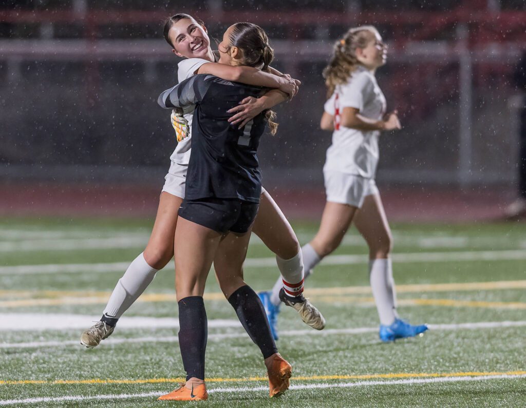 Mountlake Terrace’s Claire August runs and hugs teammate Jordyn Stokes after scoring during the 3A district game against Stanwood on Thursday, Oct. 31, 2024 in Stanwood, Washington. (Olivia Vanni / The Herald)
