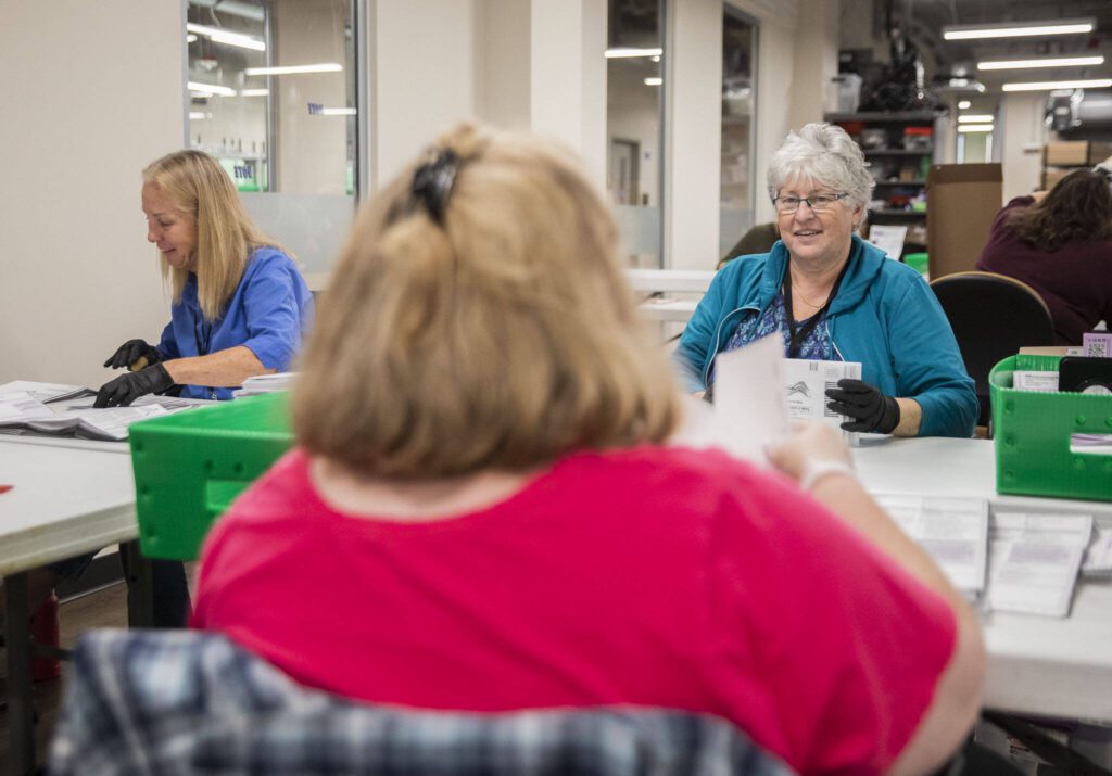Snohomish County Election employees Tressa Russell, left, Gretchen Bolton, center, and Joni Johnson, right, open ballots on Tuesday, Oct. 29, 2024 in Everett , Washington. (Olivia Vanni / The Herald)
