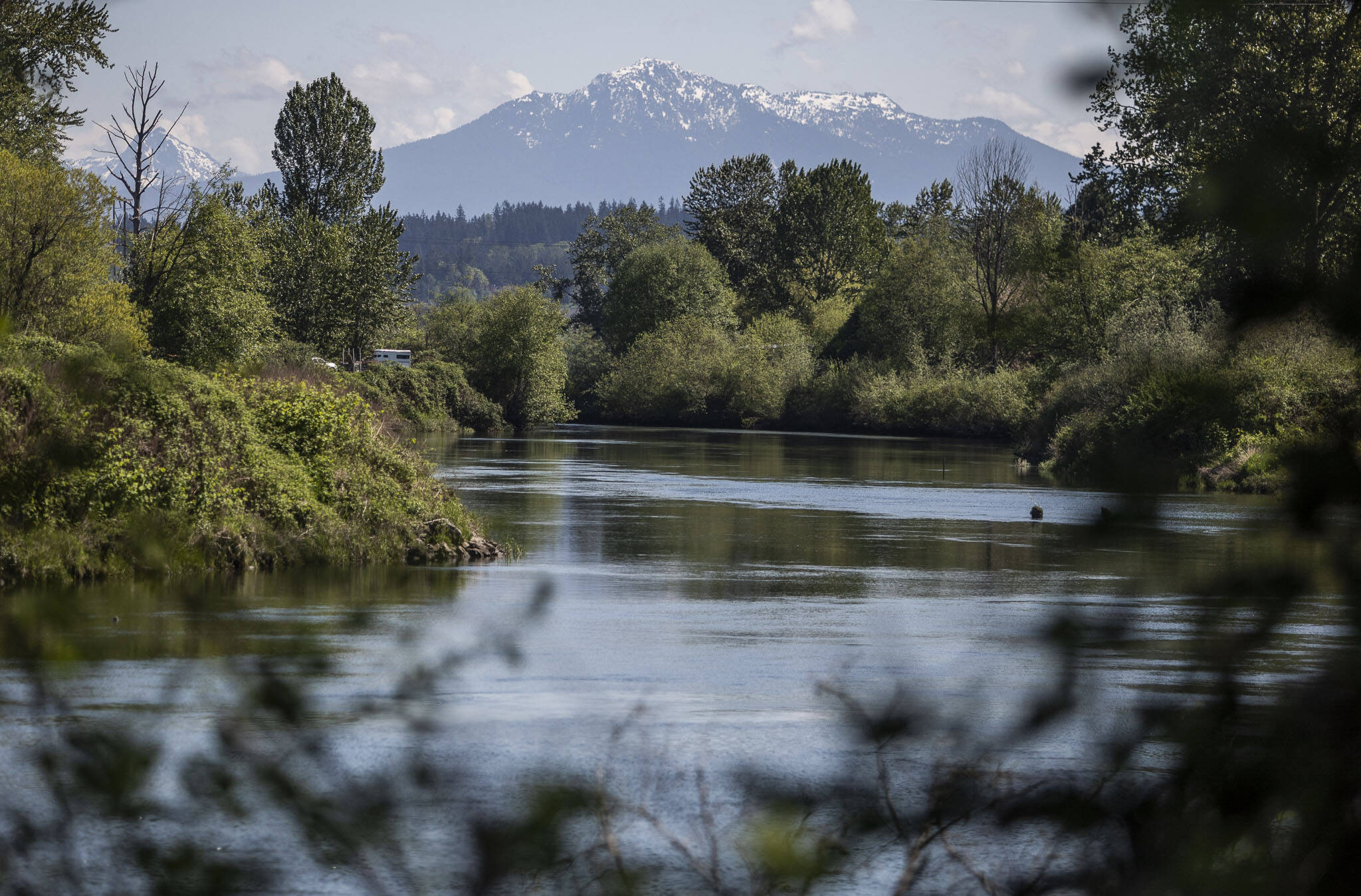 Snow is visible along the top of Mount Pilchuck from bank of the Snohomish River near Rotary Park on Wednesday, May 10, 2023 in Everett, Washington. (Olivia Vanni / The Herald)