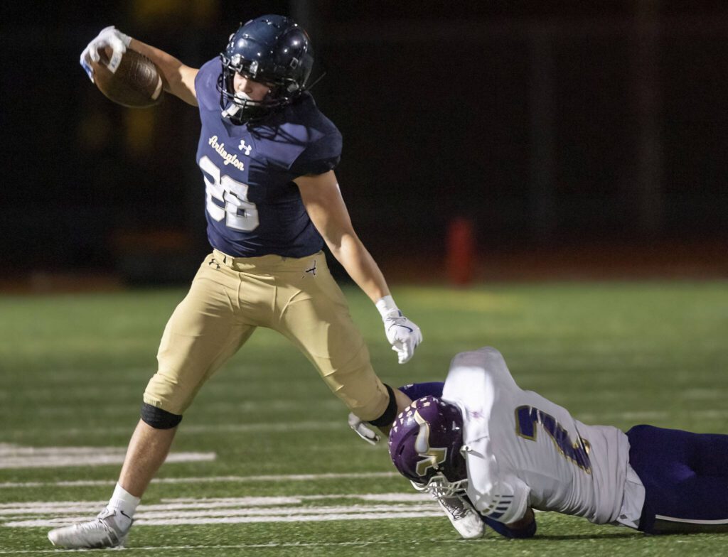 Lake Stevens’ Kekoa Okiyama hangs onto the leg of Arlington’s Caleb Reed as he runs with the ball during the game on Friday, Nov. 1, 2024 in Arlington, Washington. (Olivia Vanni / The Herald)
