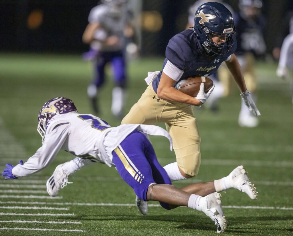 Arlington’s Jake Willis fakes out Lake Stevens’ Jaedynn Zackuse to escape a tackle during the game on Friday, Nov. 1, 2024 in Arlington, Washington. (Olivia Vanni / The Herald)
