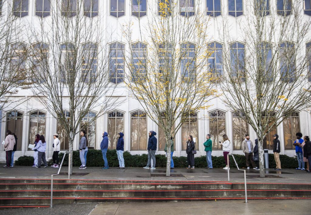 The line for the Snohomish County Auditor’s Office extends around the Admin West building on Election Day as people wait for same-day registration, ballot issuance, and accessible voting services on Tuesday, Nov. 5, 2024 in Everett, Washington. (Olivia Vanni / The Herald)
