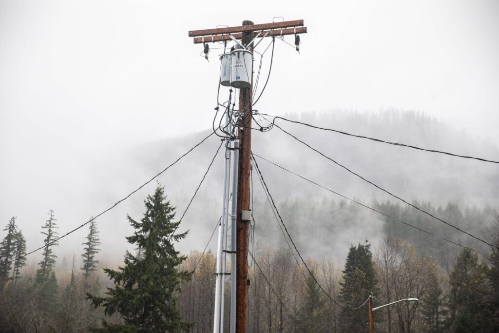 Utility lines branch off in different directions from a utility pole along Railroad Avenue on Monday, Nov. 4, 2024 in Skykomish, Washington. (Olivia Vanni / The Herald)
