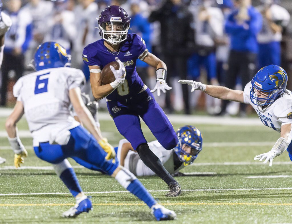 Lake Stevens’ Blake Moser dodges multiple tackles while running the ball down the field during the 4A district game against Tahoma on Friday, Nov. 8, 2024 in Lake Stevens, Washington. (Olivia Vanni / The Herald)
