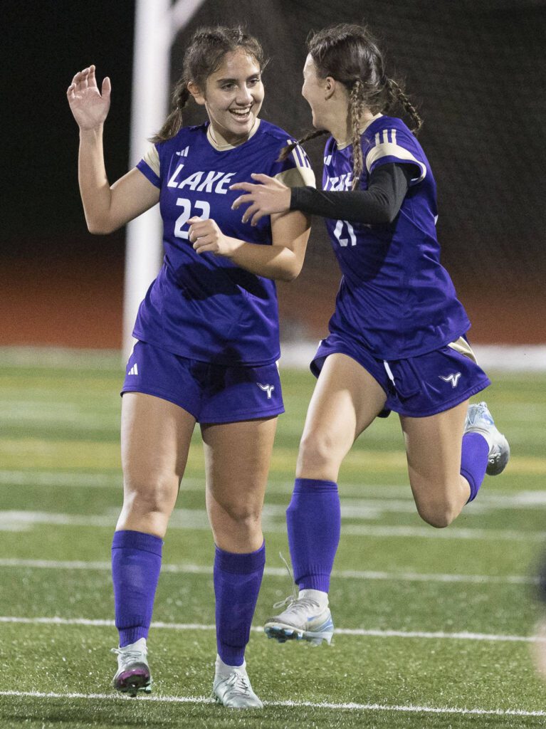 Lake Stevens’ Mia Ingram leaps in the air with teammate Lake Stevens’ Amira Yaser in celebration after beating Richland in the 4A state playoff game on Wednesday, Nov. 13, 2024 in Lake Stevens, Washington. (Olivia Vanni / The Herald)
