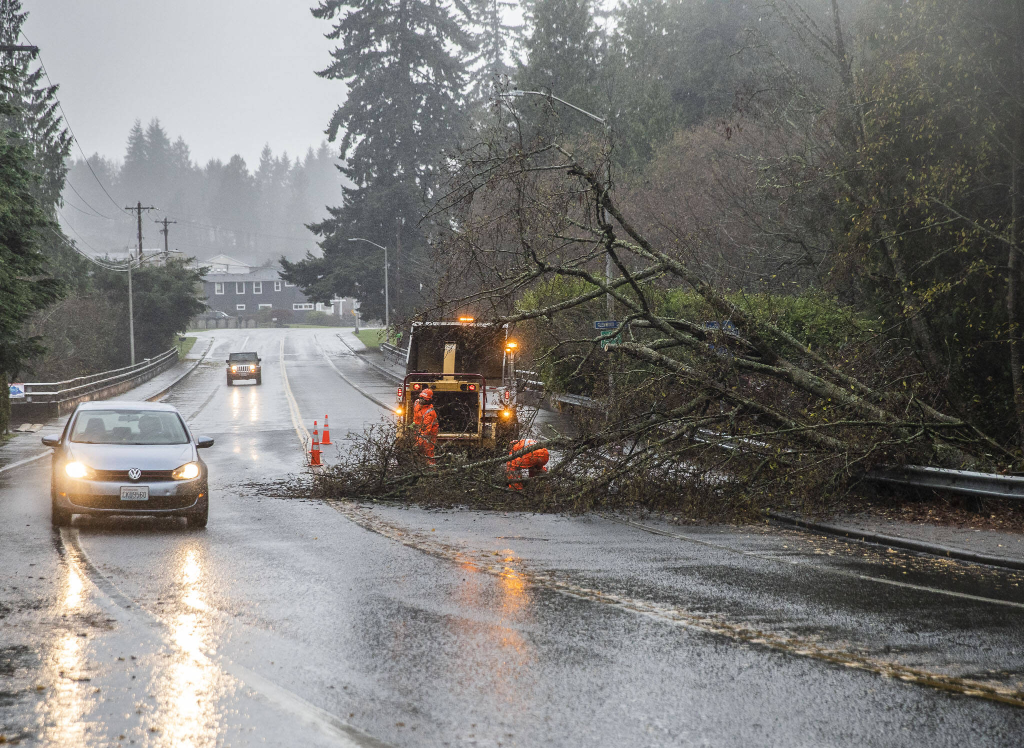 Drivers navigate around a downed tree across Mukilteo Boulevard while crews work to clear the road in December 2023 in Everett. (Olivia Vanni / Herald file)