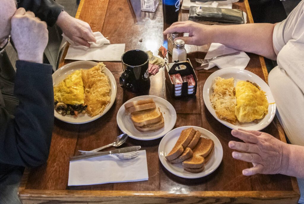Paul Pollard and James Mock chat over their lunch at Buzz Inn Steakhouse on Tuesday, Dec. 3, 2024 in Everett, Washington. (Olivia Vanni / The Herald)
