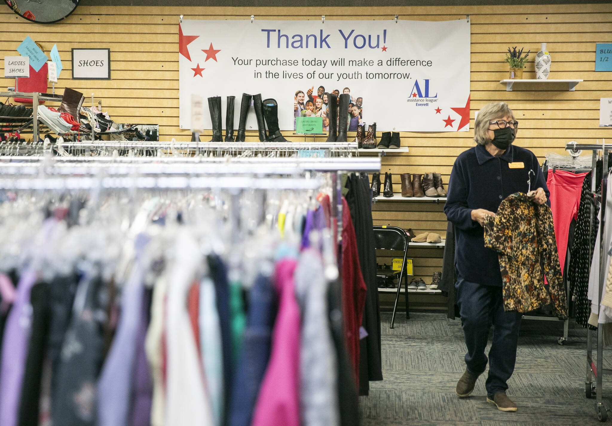 Jeanne Hoek hangs clothing on racks at the Assistance League of Everett’s Thrift Store on Monday, Dec. 2, 2024 in Everett, Washington. (Olivia Vanni / The Herald)