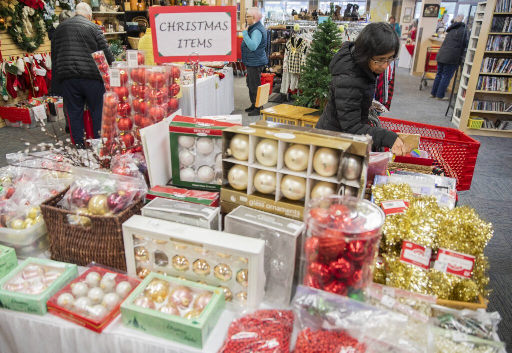 People look through the Christmas items on sale at the Assistance League of Everett’s Thrift Store on Monday, Dec. 2, 2024 in Everett, Washington. (Olivia Vanni / The Herald)
