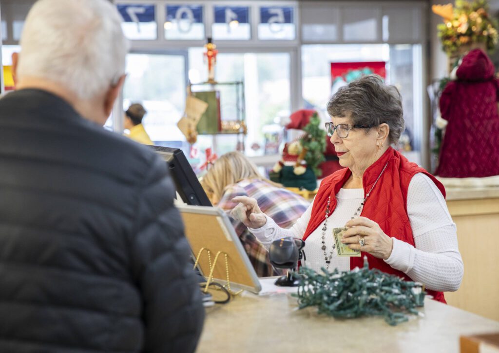 Judi Drake rings up a customer at the Assistance League of Everett’s Thrift Store on Monday, Dec. 2, 2024 in Everett, Washington. (Olivia Vanni / The Herald)
