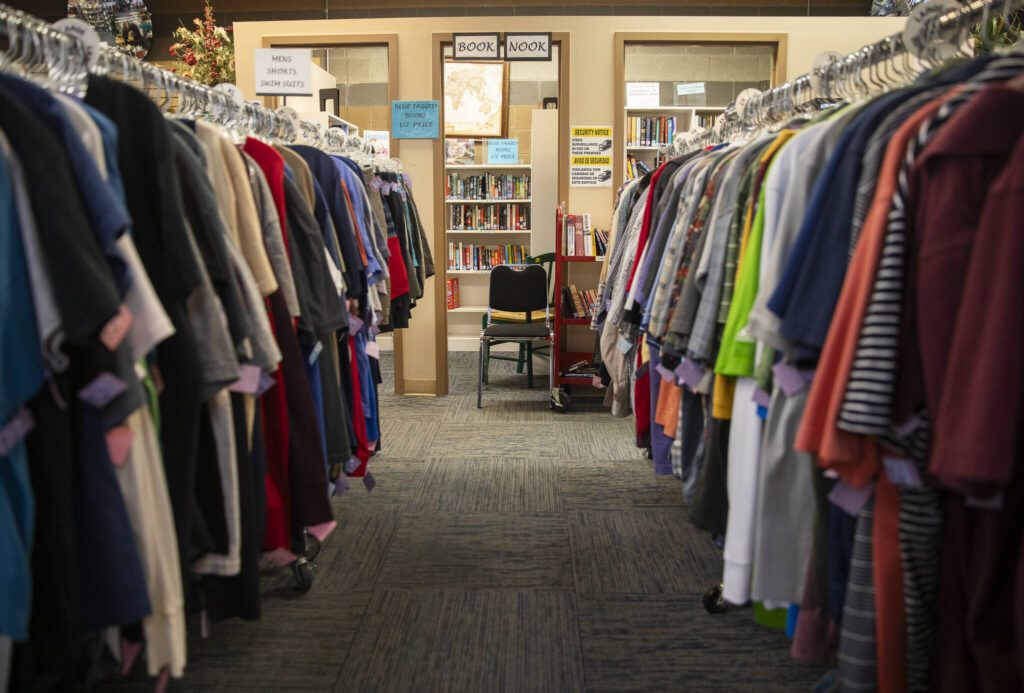 Rows of shirts lead the way to the “Book Nook” at the Assistance League of Everett’s Thrift Store on Monday, Dec. 2, 2024 in Everett, Washington. (Olivia Vanni / The Herald)
