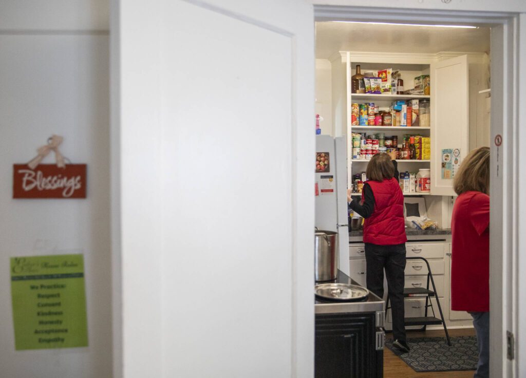 Volunteers help organize the pantry at Esther’s Place on Wednesday, Dec. 4, 2024 in Everett, Washington. (Olivia Vanni / The Herald)
