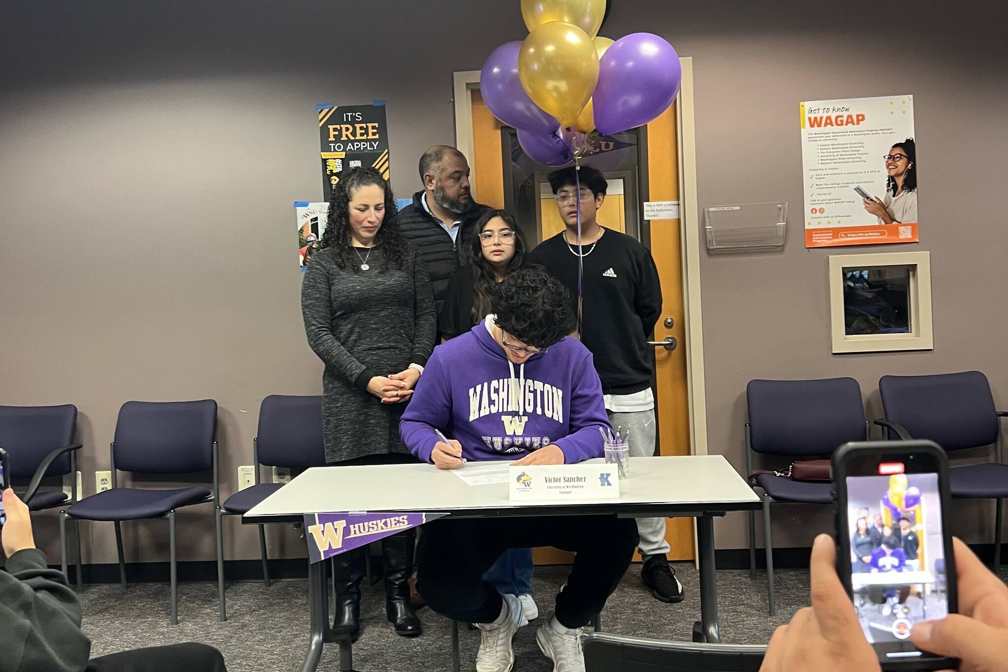 Victor Sanchez Hernandez Jr. signs his letter of intent to play football at the University of Washington on Dec. 4, 2024 at Kamiak High School. (Photo courtesy of Ezra Davis)