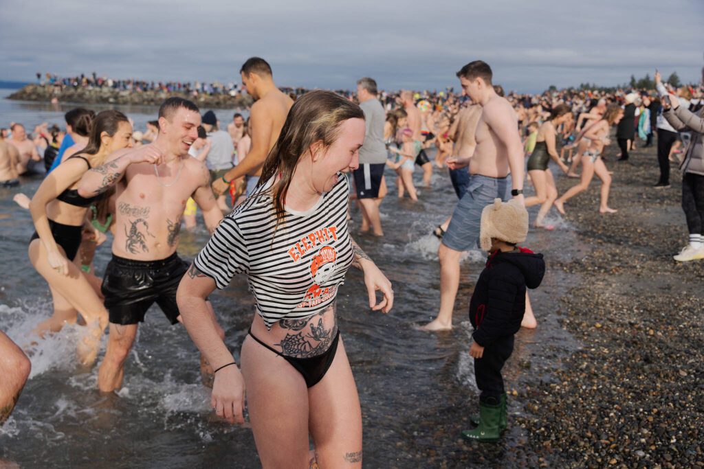 Kaley Rose runs out of the Puget Sound after taking the cold plunge on Wednesday, Jan. 1, in Edmonds, Washington. (Will Geschke / The Herald)
