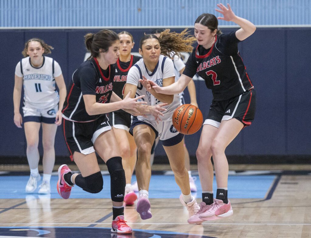 Meadowdale’s Kaiya Dotter scrambles for a close ball with Archbishop Murphy’s Ava Marr and Brooke Blachly during the game on Friday, Jan. 3, 2025 in Lynnwood, Washington. (Olivia Vanni / The Herald)
