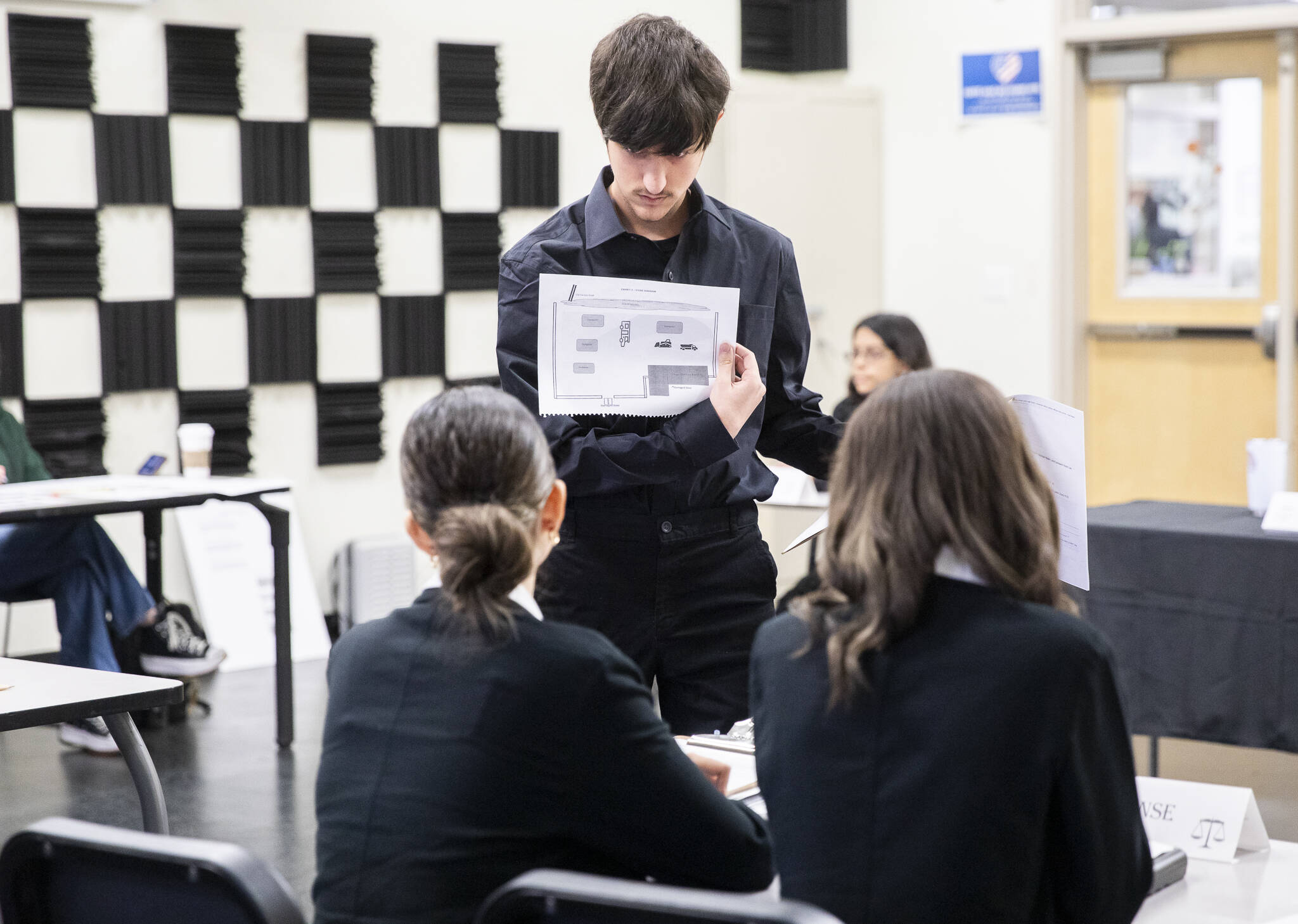 Braedon Bracero presents evidence to be admitted to the defense during a mock trial at 10th Street Middle School on Friday, Jan. 10, 2025, in Marysville, Washington. (Olivia Vanni / The Herald)