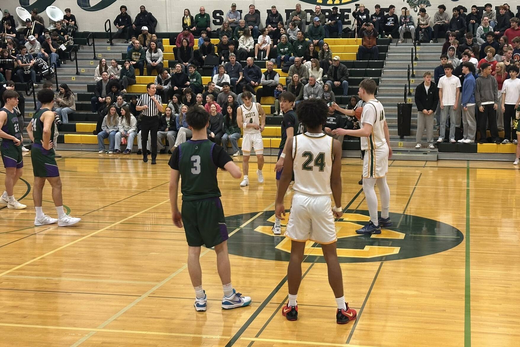 Edmonds-Woodway boys basketball (green) and Shorecrest (white) prepare for tipoff ahead of a league matchup at Shorecrest High School on Jan. 8, 2025. (Qasim Ali / The Herald)