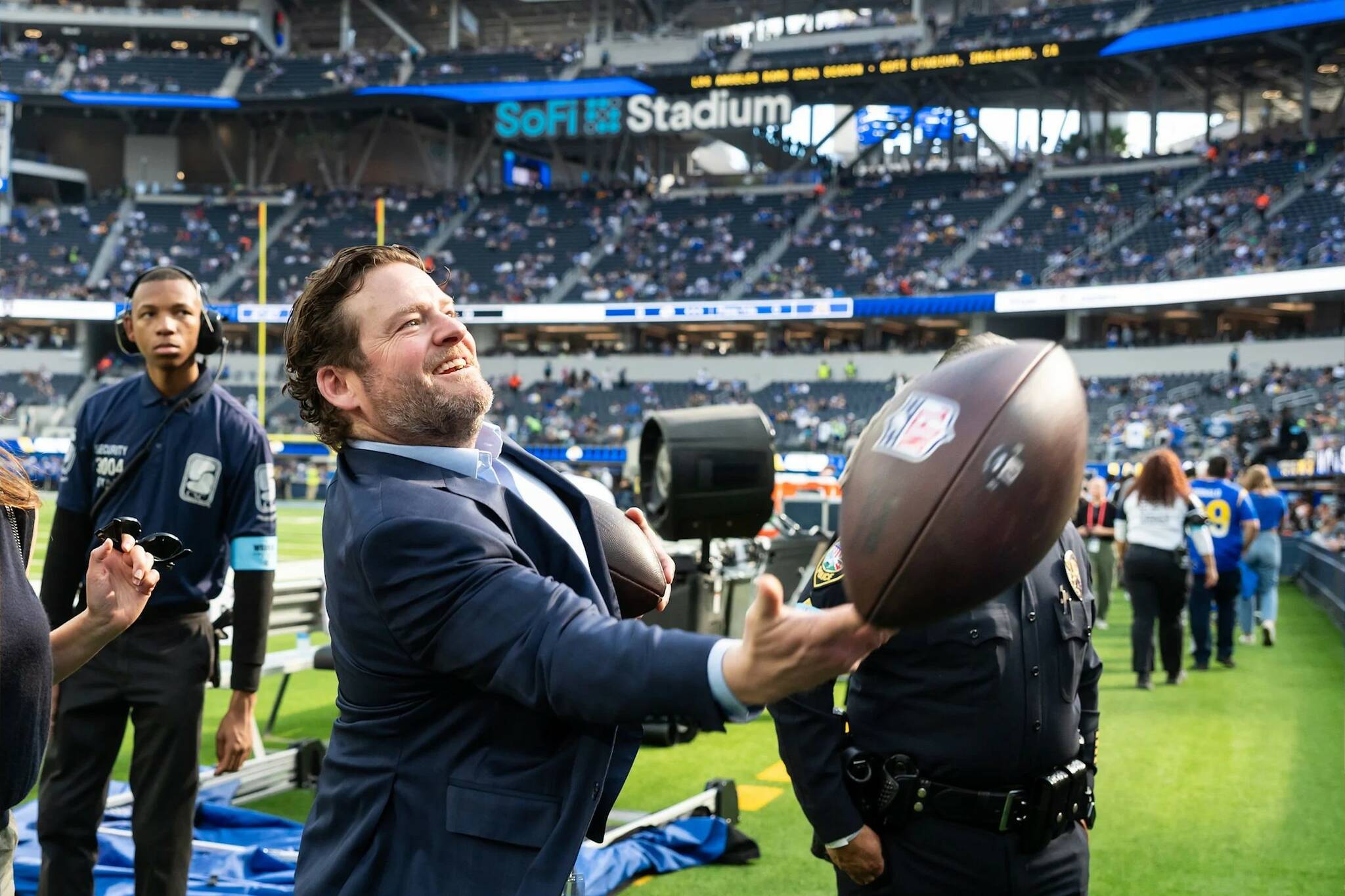 Seahawks president of football operations / general manager John Schneider tosses a football to a Seahawks fan sitting behind the Seattle’s bench before a game against the Los Angeles Rams at SoFi Stadium on Jan. 5, 2025. (Photo courtesy of Rod Mar / Seattle Seahawks)