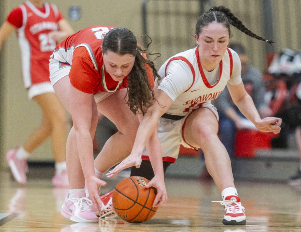 Stanwood’s Jazmyn Legg and Snohomish’s Sienna Capelli scramble for a loose ball during the game on Thursday, Jan. 9, 2025 in Snohomish, Washington. (Olivia Vanni / The Herald)
