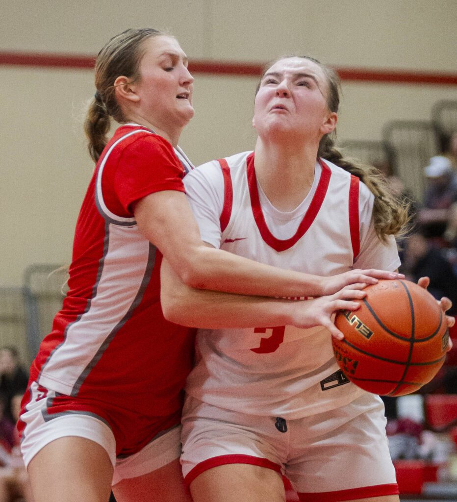 Stanwood’s Ava DePew fouls Snohomish’s Kendall Hammer as she tries to take a shot during the game on Thursday, Jan. 9, 2025 in Snohomish, Washington. (Olivia Vanni / The Herald)
