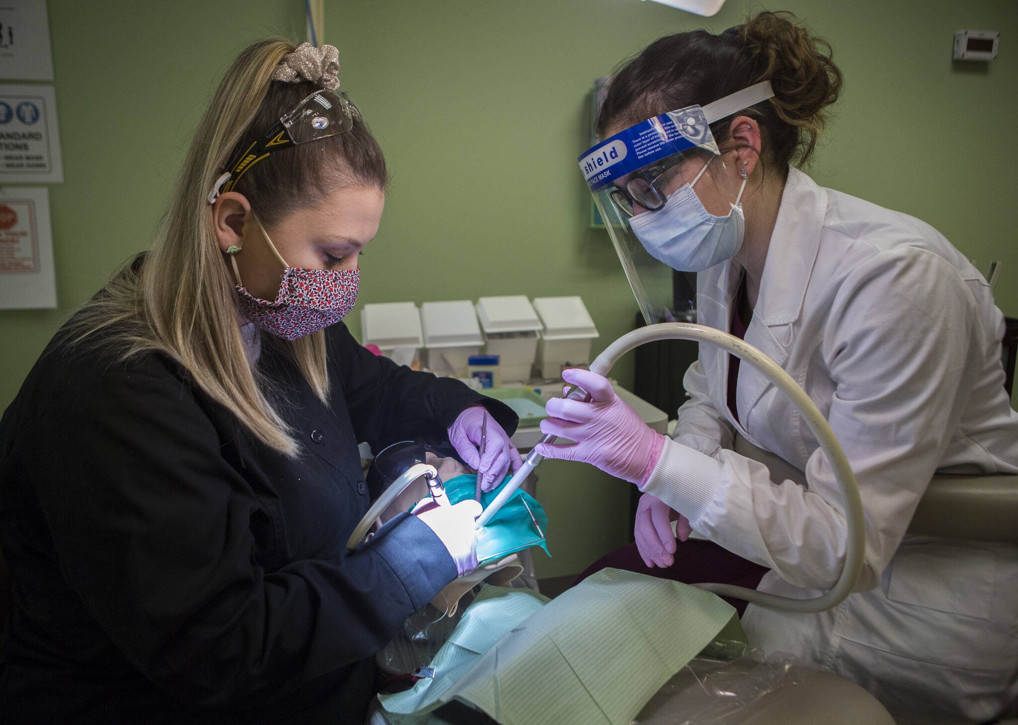 Brecca Yates (left) helps guide dental student Kaylee Andrews through a crown prep exercise at Northshore Dental Assisting Academy on in April, 2021 in Everett. (Olivia Vanni / The Herald file photo)