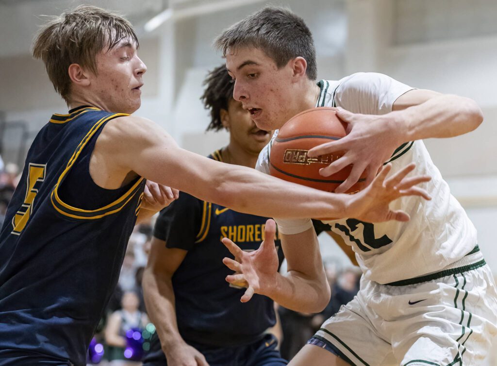 Edmonds-Woodway’s William Alseth tries to keep the ball away from the outstretched arm of Shorecrest’s Brayden Fischer during the game on Tuesday, Jan. 28, 2025 in Edmonds, Washington. (Olivia Vanni / The Herald)

