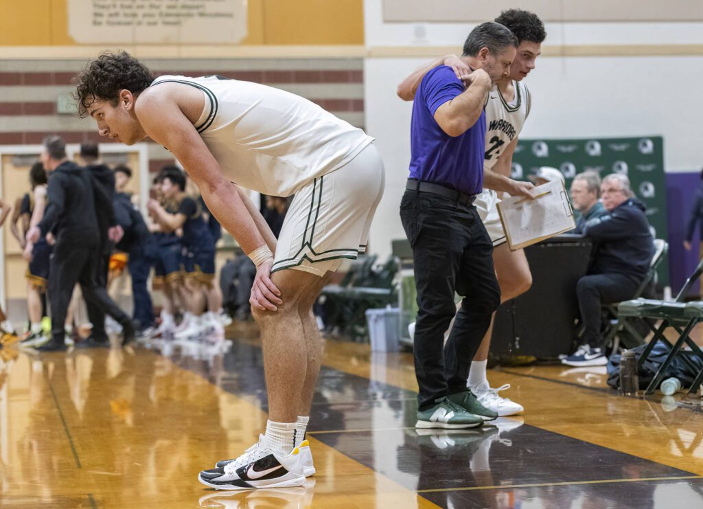 Edmonds-Woodway’s Cam Hiatt places his hands on his knees as multiple teammates are helped off the floor in the final minutes of the game against Shorecrest on Tuesday, Jan. 28, 2025 in Edmonds, Washington. (Olivia Vanni / The Herald)
