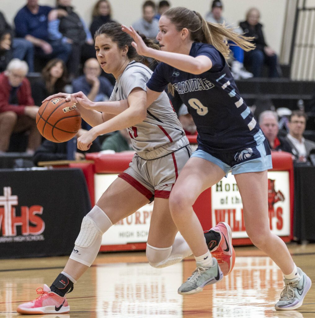 Meadowdale’s Payton Fleishman tries to the knock the ball away from Archbishop Murphy’s Ava Marr during the game on Thursday, Jan. 30, 2025 in Everett, Washington. (Olivia Vanni / The Herald)
