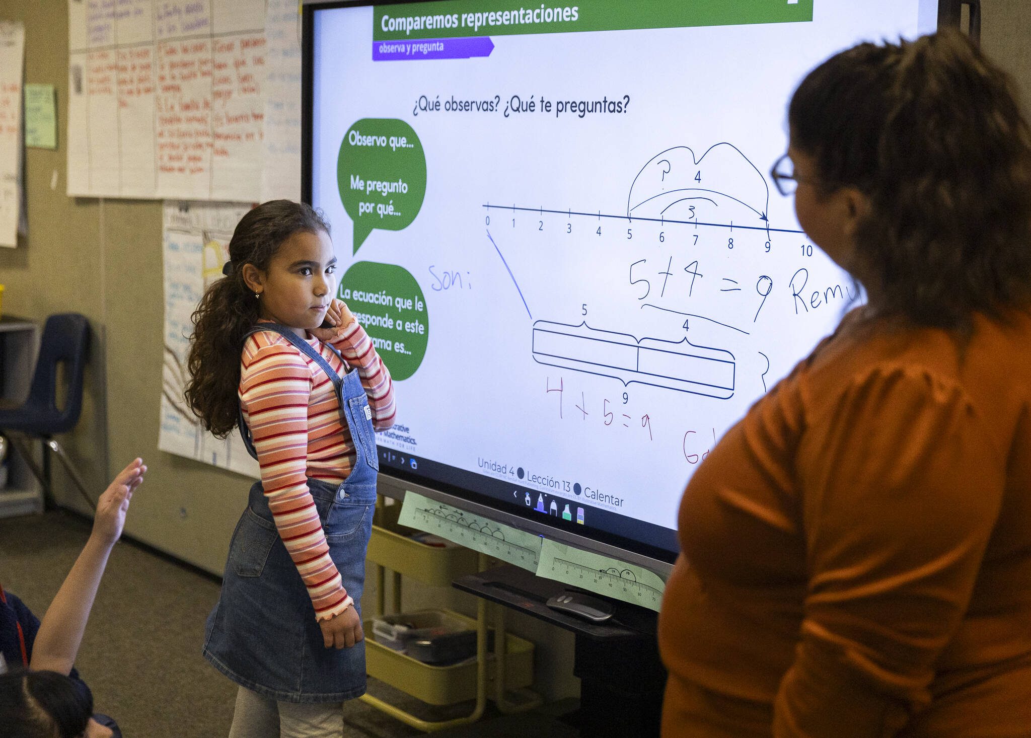Isabella Eldridge, 8, a second grader at Emerson Elementary School, works through a math problem on the board with the help of her dual language class teacher Paola Martinez on Thursday, Jan. 30, 2025 in Everett, Washington. (Olivia Vanni / The Herald)