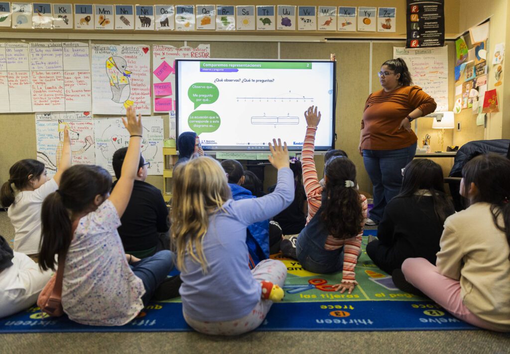 Second grade teacher Paola Martinez asks her class to raise their hands when they think they know the answer to the prompt on the board during dual language class at Emerson Elementary School on Thursday, Jan. 30, 2025 in Everett, Washington. (Olivia Vanni / The Herald)
