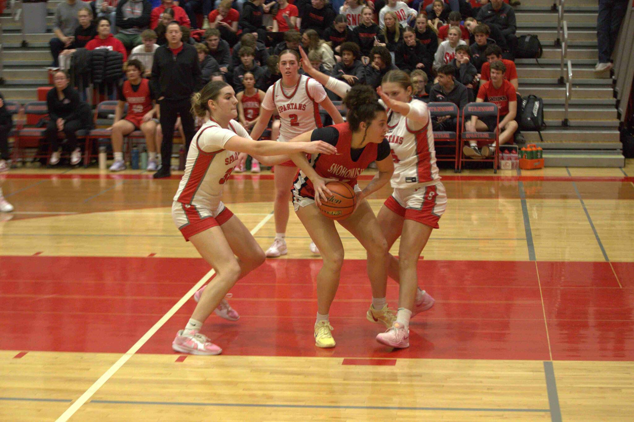 Snohomish's Tyler Gildersleeve-Stiles (34) is surrounded by the Stanwood defense of Stella Berrett (35), and Ava DePew (5) in a Wesco 3A/2A game in Stanwood on Jan. 31, 2025. (Aaron Coe / The Herald)