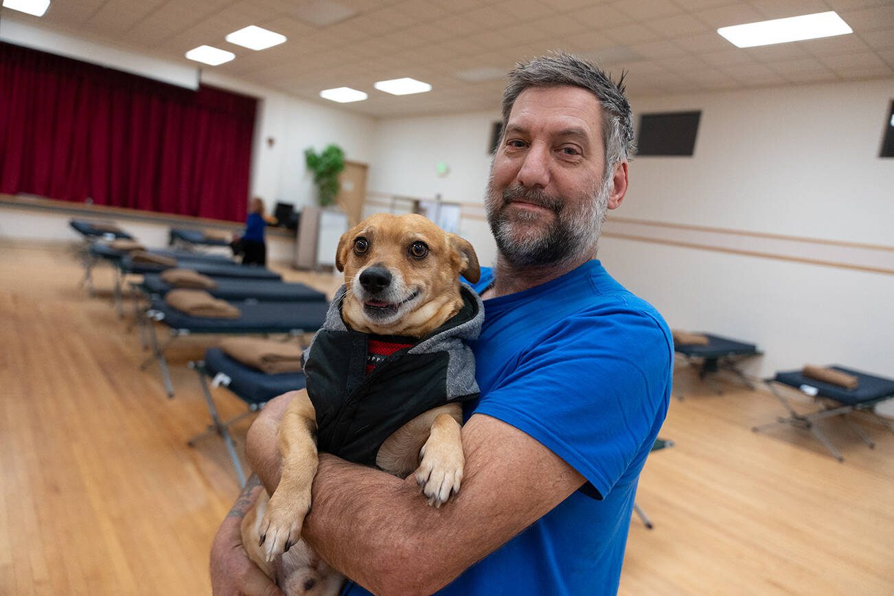 Timothy Evans, a volunteer at the east Everett cold weather shelter, with his dog Hammer on Monday, Feb. 10 in Everett, Washington. (Will Geschke / The Herald)