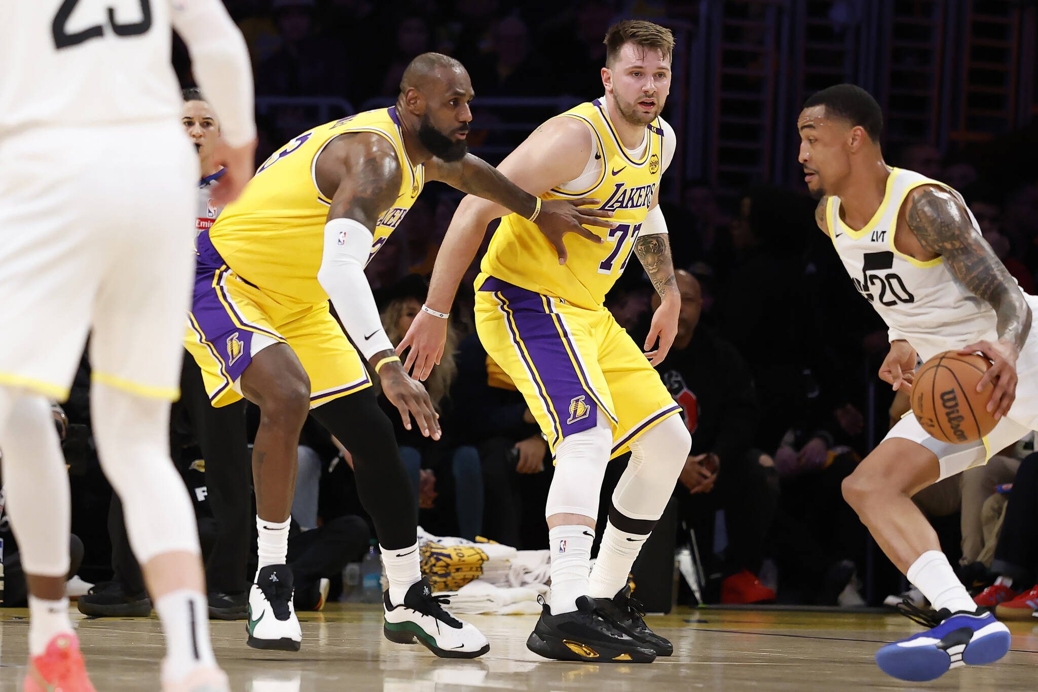 LeBron James (23) and Luka Doncic (77) of the Los Angeles Lakers look on as John Collins (20) of the Utah Jazz drives to the basket during the first quarter at Crypto.com Arena on Monday, Feb. 10, 2025, in Los Angeles. (Ronald Martinez / Getty Images / Tribune News Services)