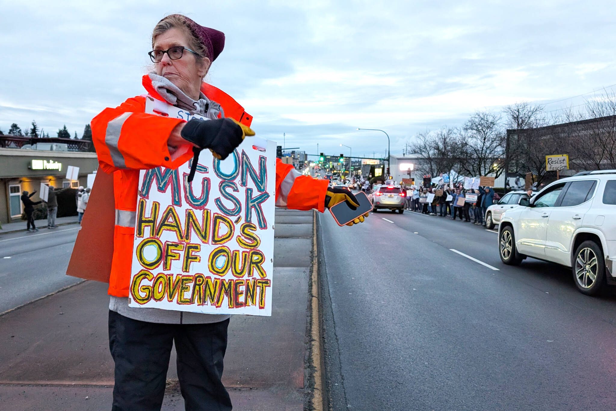 Cheryl Pearson, 70, waves to passing motorists during a rally and food drive sponsored by Snohomish County Indivisible on Monday, Feb. 17, 2025, in Everett, Washington. (Michael Henneke / The Herald)
Cheryl Pearson, 70, waves to passing motorists during a rally and food drive sponsored by Snohomish County Indivisible on Monday, Feb. 17, 2025, in Everett, Washington. (Michael Henneke / The Herald)