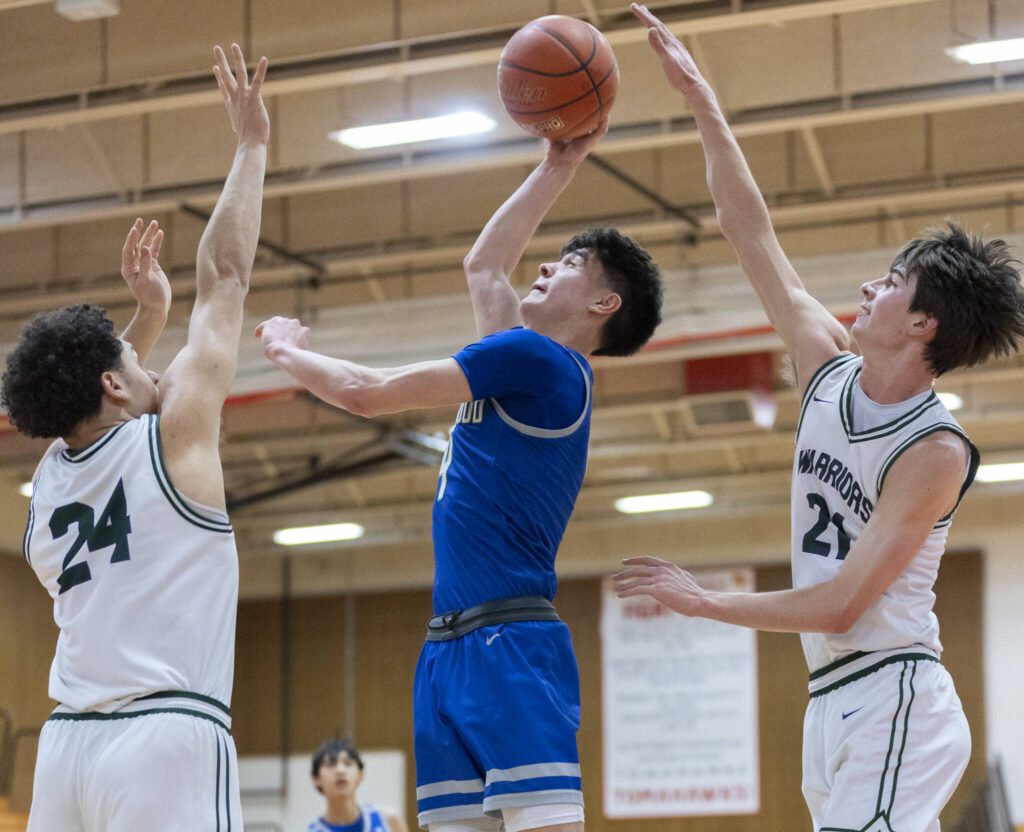 Edmonds-Woodway’s Julian Gray and Luke Boland both reach up to try and block a shot by Shorewood’s Max Nguyen during the 3A district semifinal game on Wednesday, Feb. 19, 2025 in Marysville, Washington. (Olivia Vanni / The Herald)
