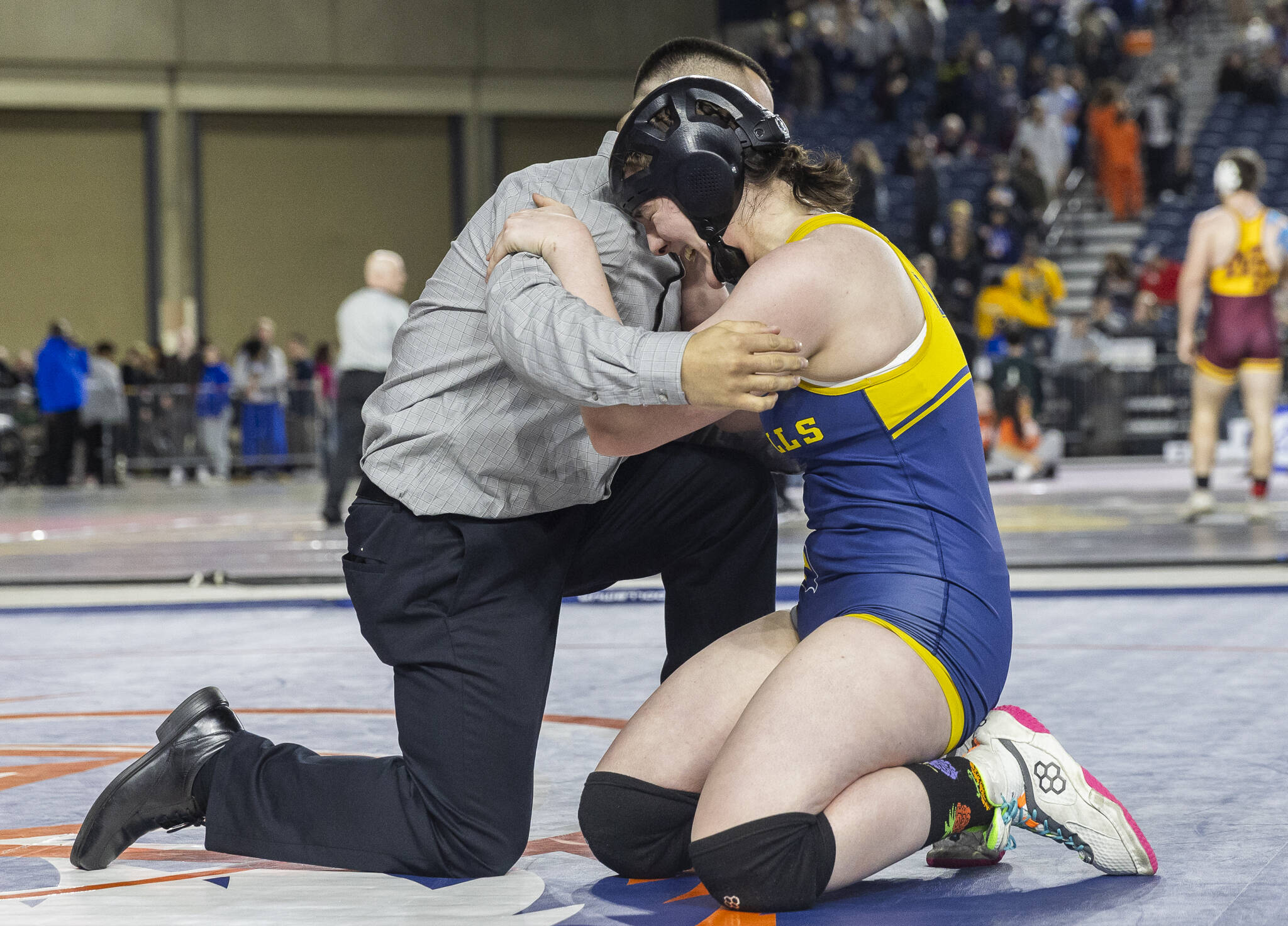 Everett’s Mia Cienga hugs her coach after winning the 3A girls 190-pound title after an undefeated season at the Mat Classic on Friday, Feb. 21, 2025 in Tacoma, Washington. (Olivia Vanni / The Herald)