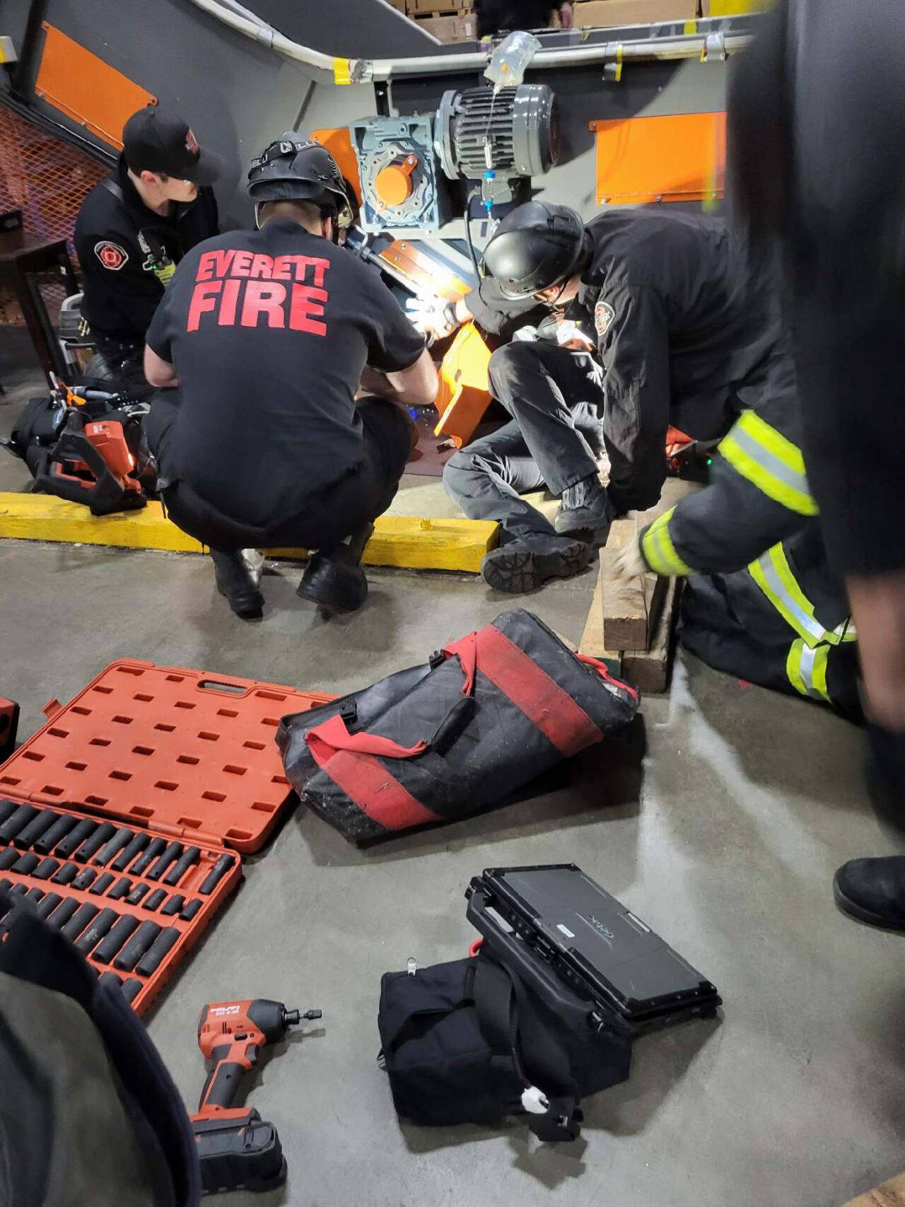 Firefighters work to rescue a man whose arm became trapped in a baler Tuesday in Everett. (Everett Fire Department)
