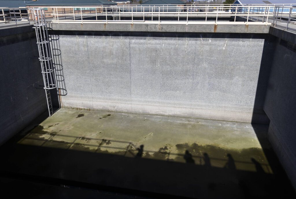 Shadows are cast across one of the Port Gardner Storage Facility’s 50-by-50, 30-foot-deep cement tanks on Thursday, Feb. 27, 2025 in Everett, Washington. (Olivia Vanni / The Herald)
