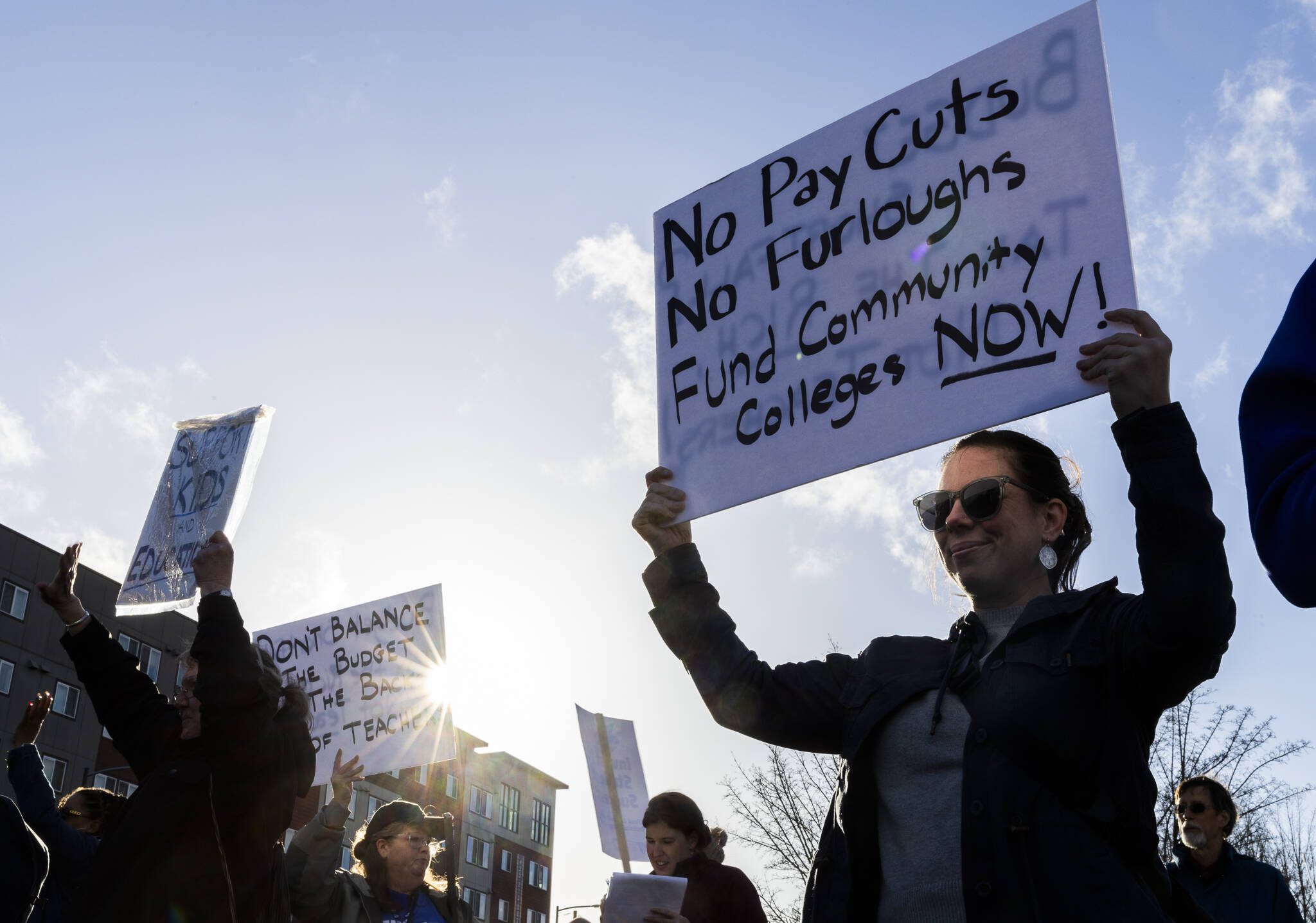 Brienne Townsend holds a sign encouraging the funding of community colleges during a Edmonds College faculty union rally as part of a national day of action outside of the Lynnwood Event Center on Tuesday, March 4, 2025 in Lynnwood, Washington. (Olivia Vanni / The Herald)