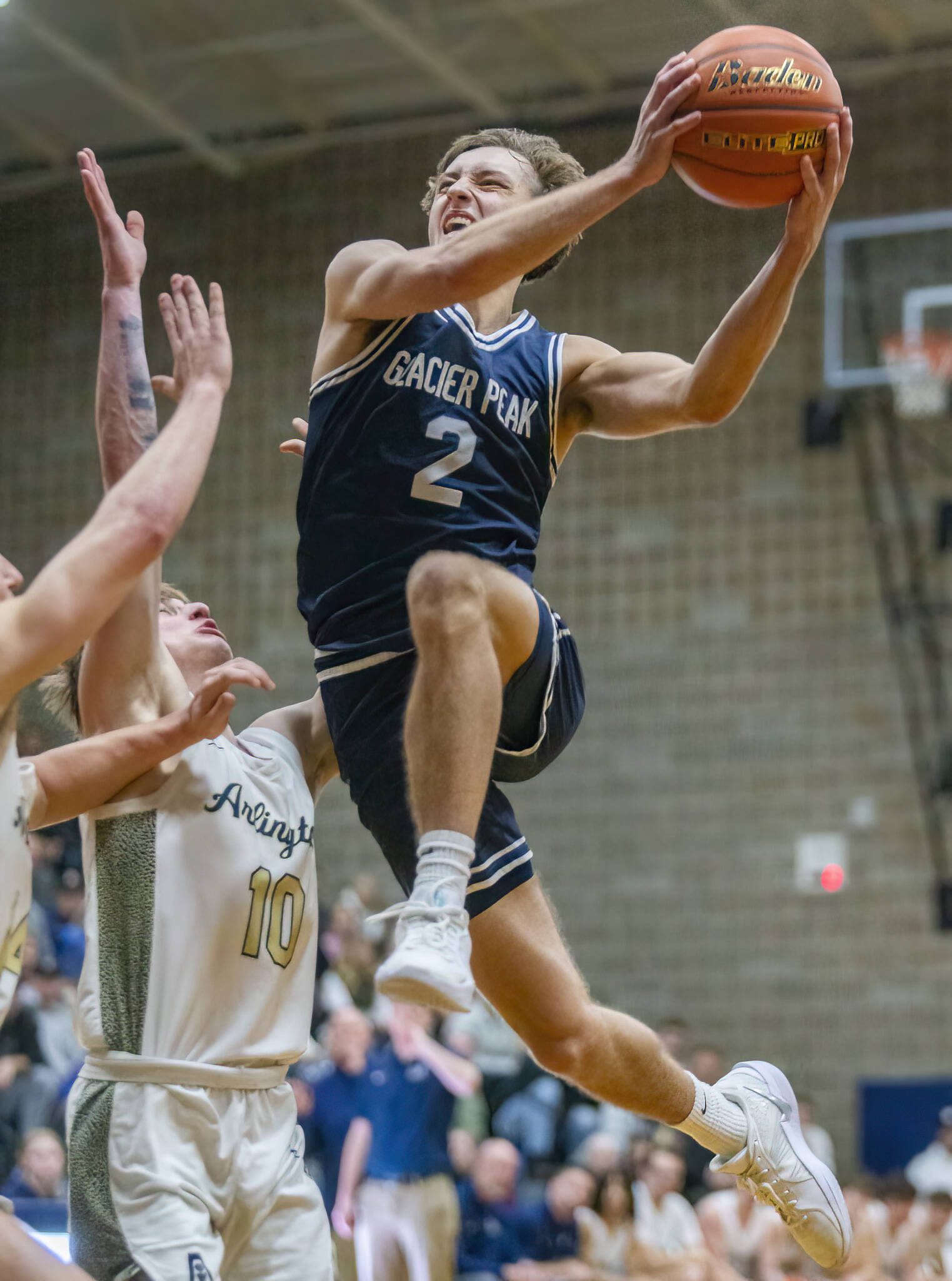 Glacier Peak’s Jo Lee leaps in the air past multiple Arlington players to make a layup during the game on Friday, Jan. 17, 2025 in Arlington, Washington. (Olivia Vanni / The Herald)