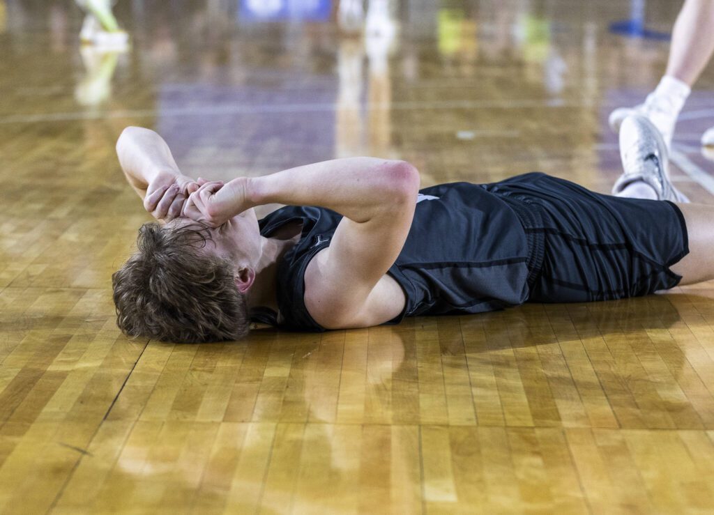 Glacier Peak’s Reed Nagel lays on the ground after getting a foul called on him during the 4A boys semifinal game against Gonzaga Prep on Friday, March 7, 2025 in Tacoma, Washington. (Olivia Vanni / The Herald)
