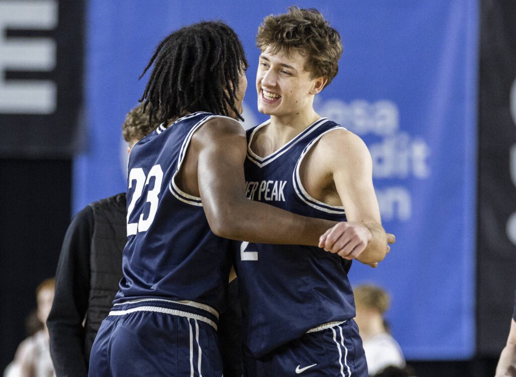 Glacier Peak’s Jo Lee is hugged by his teammate Paulos Mulugeta after winning the 4A boys quarterfinal game against Camas on Thursday, March 6, 2025 in Tacoma, Washington. (Olivia Vanni / The Herald)
