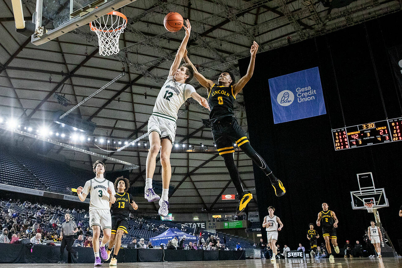 Edmonds-Woodway’s William Alseth has his arm grabbed by Lincoln’s Trey Collier while trying to shoot a layup during the 3A boys quarterfinal game on Thursday, March 6, 2025 in Tacoma, Washington. (Olivia Vanni / The Herald)