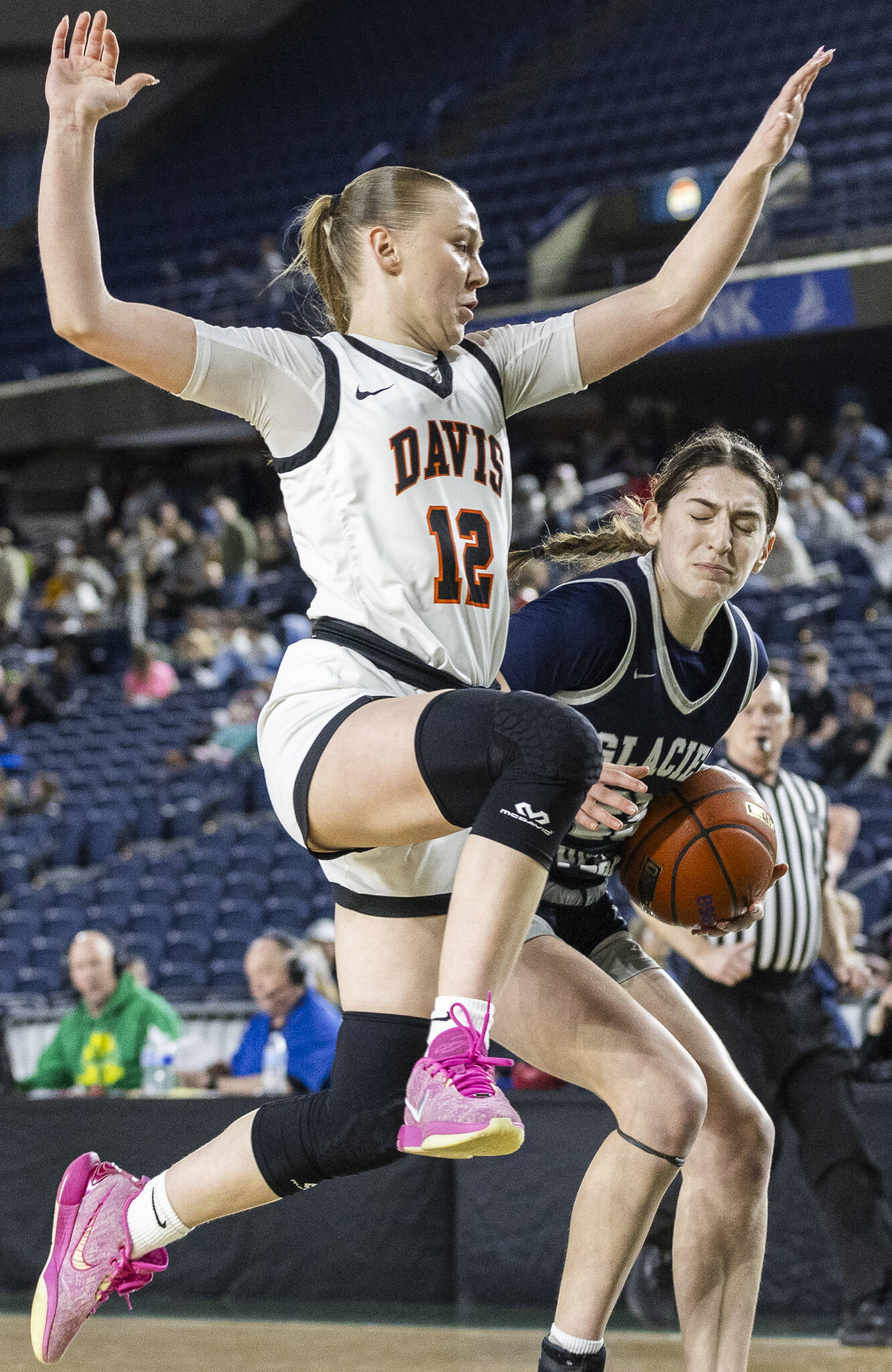 Glacier Peak’s Lillian Riechelson grimaces as Davis’ Ella Craig leaps into her during the 4A girls semifinal game on Friday, March 7, 2025 in Tacoma, Washington. (Olivia Vanni / The Herald)